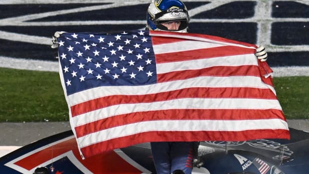 Justin Allgaier, driver of the #7 Unilever Military DeCA RCPT Chevrolet, celebrates with the American flag after winning Monday's twice-postponed (due to rain) Xfinity Series Alsco Uniforms 300 at Charlotte Motor Speedway. (Photo by Logan Riely/Getty Images)